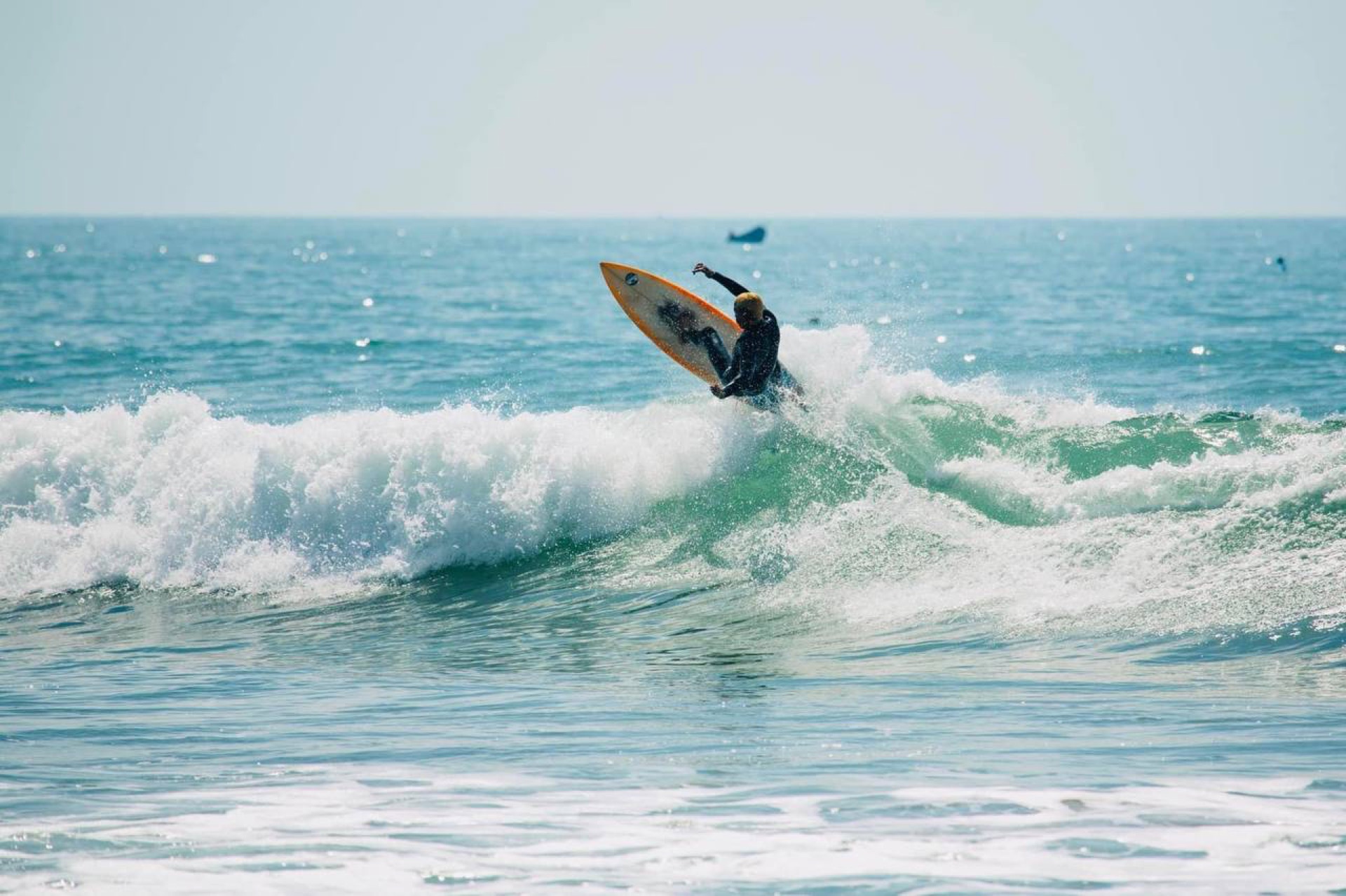 Surfer on golden board at Banana Point