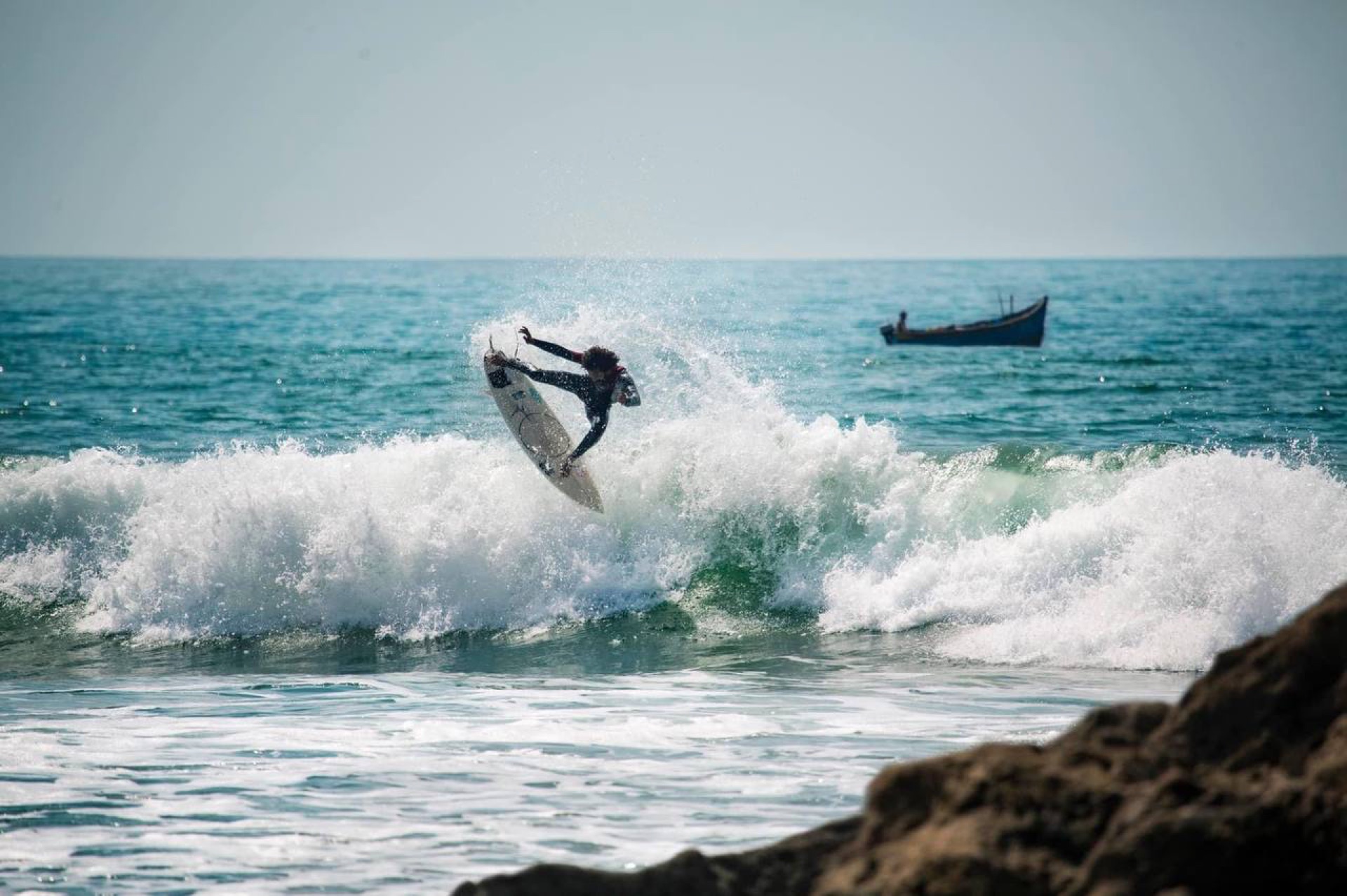 Surfer launching above a wave at Banana Point in Aourir